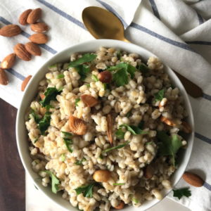 A bowl of Barley and topped with nuts