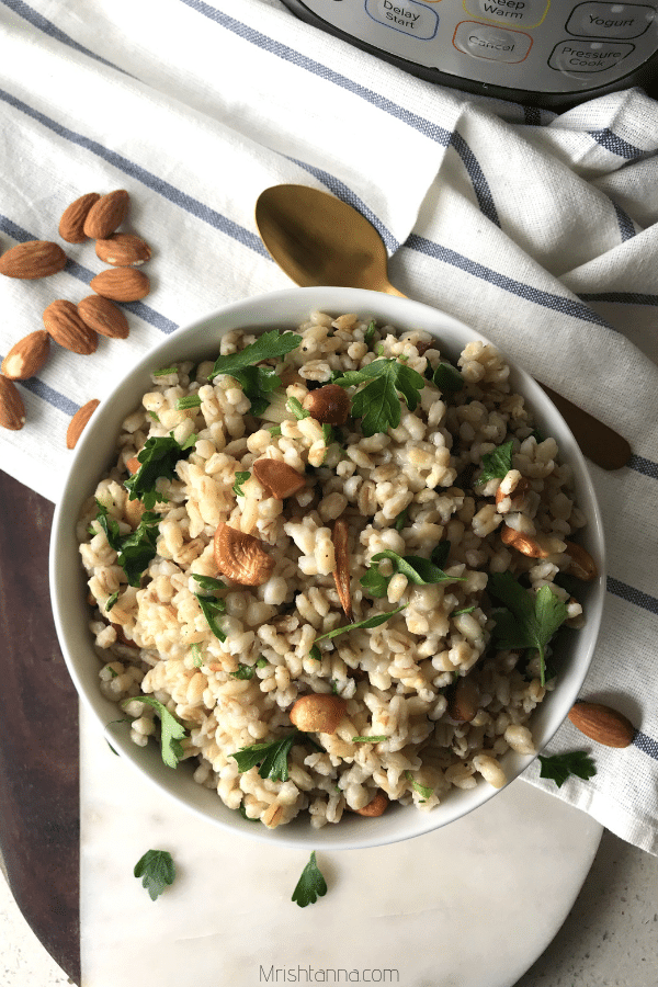 A bowl of Barley and topped with nuts