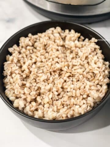 A bowl of cooked barley is on the table.