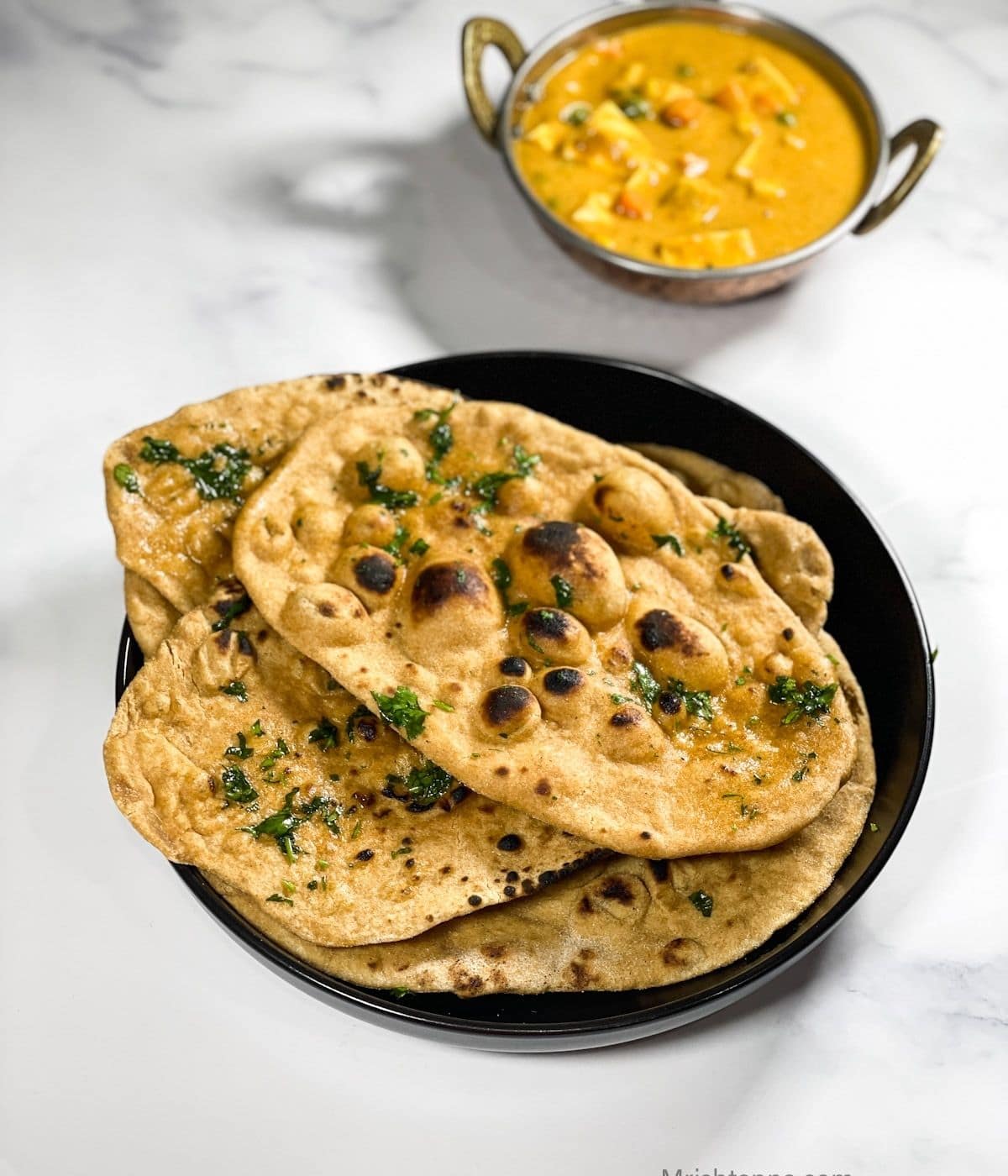 A plate of wheat naan are on the table.