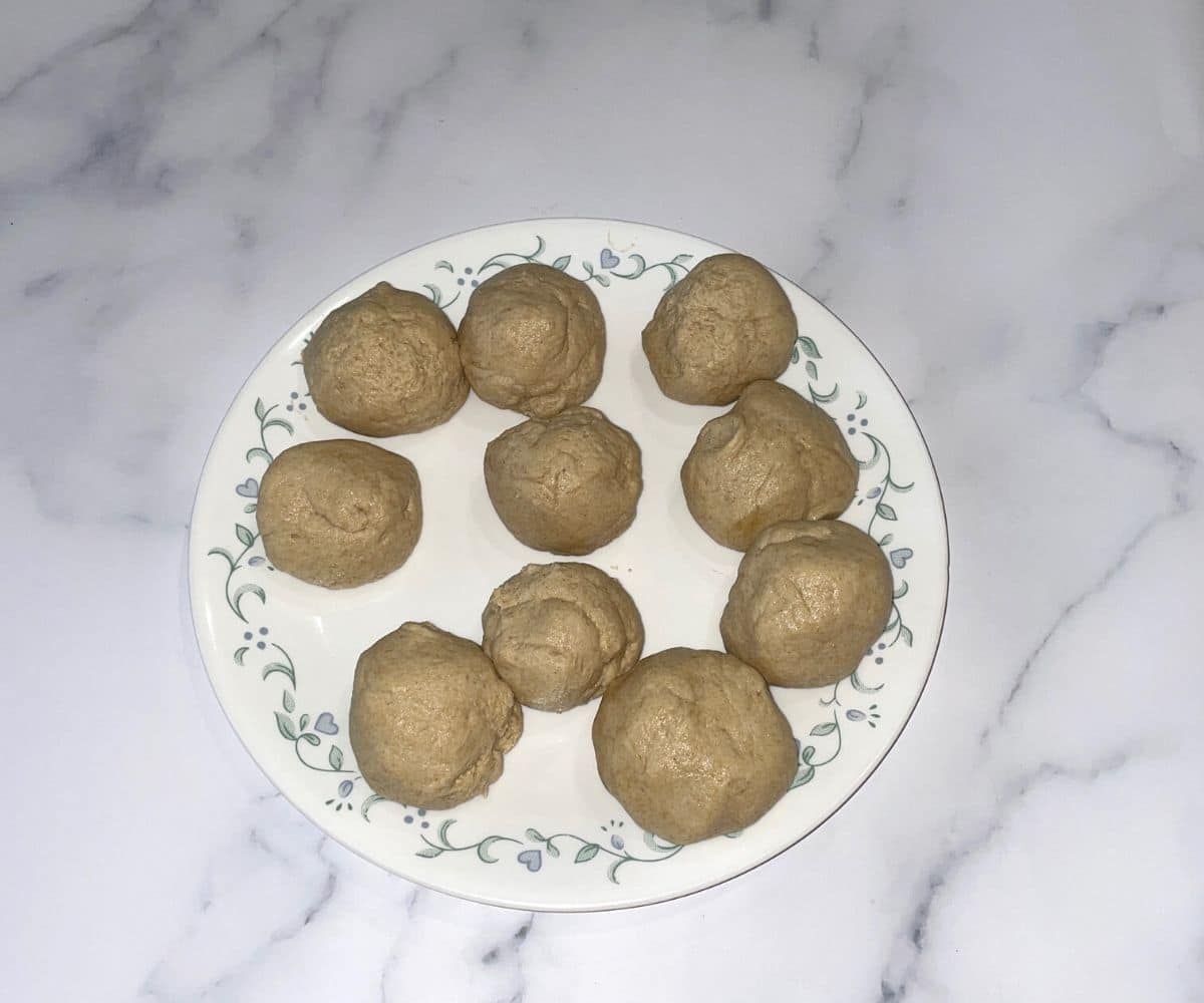 A plate is with wheat naan dough balls.