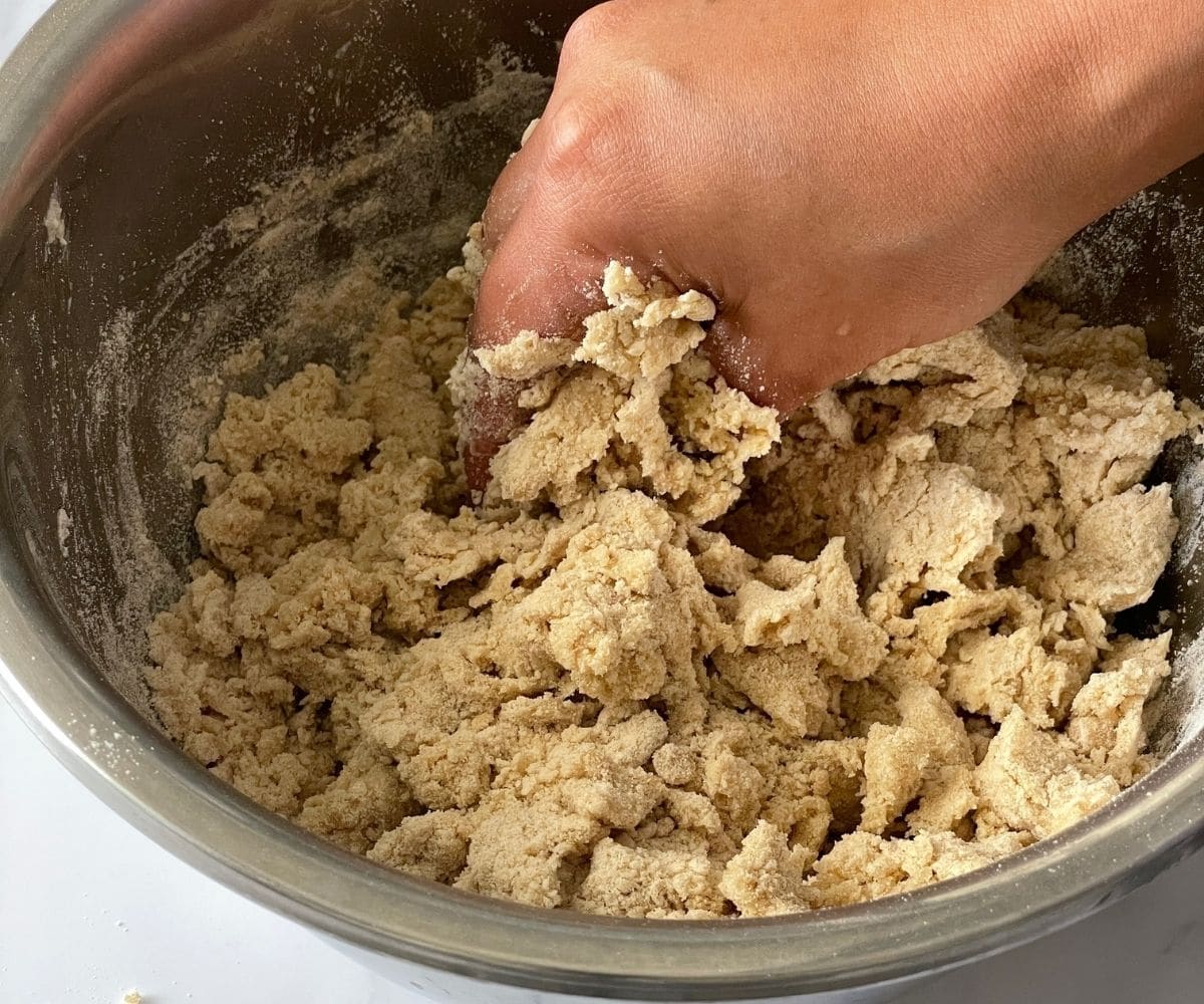 A hand mixing the naan dough.