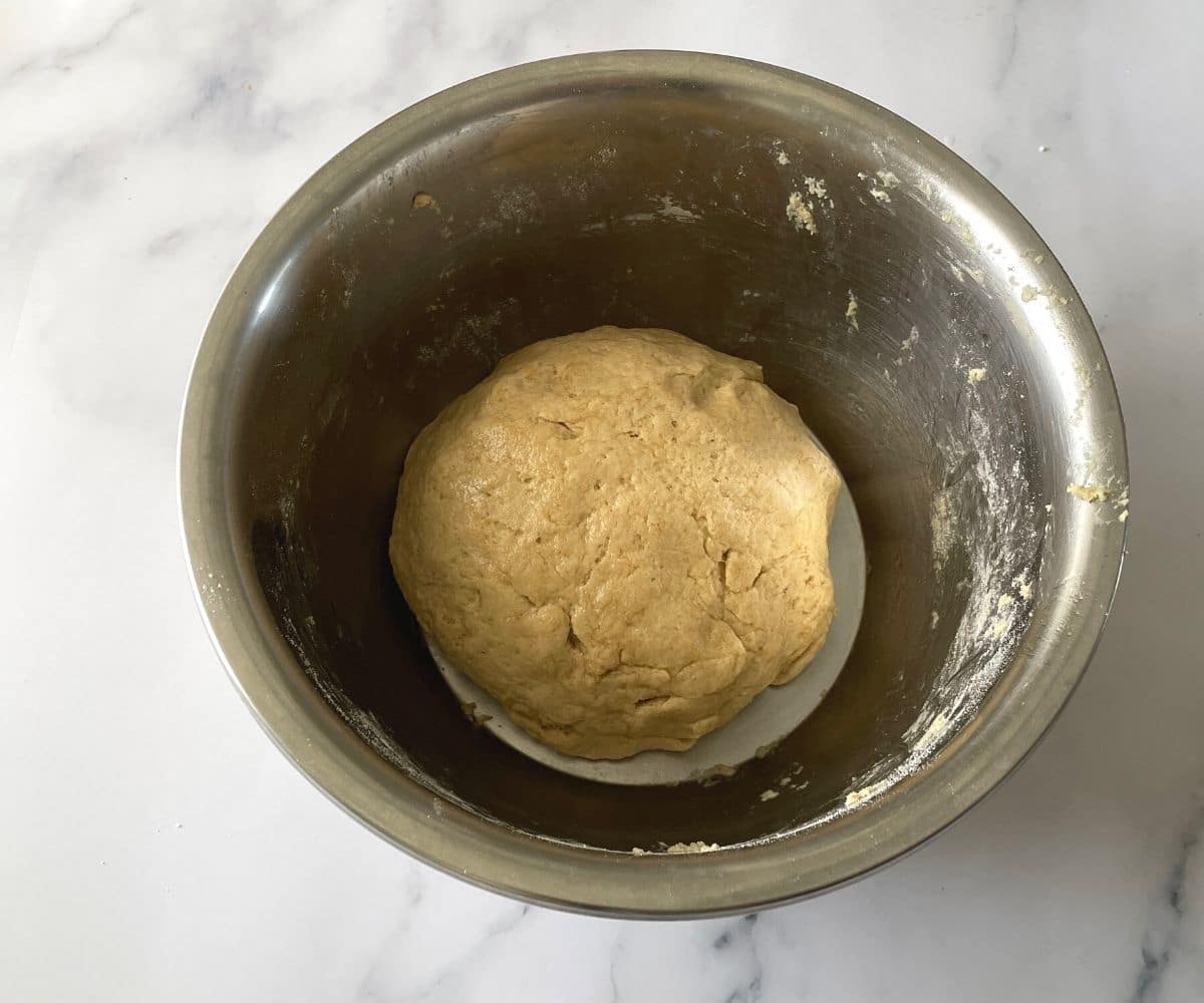 A bowl is with vegan naan dough.