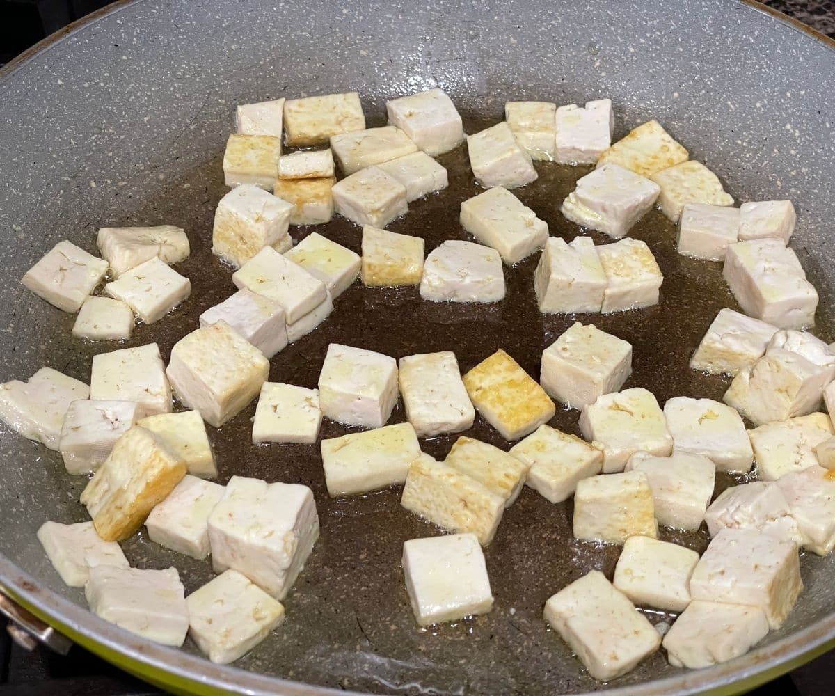 A pan is with oil and extra firm tofu over the heat.