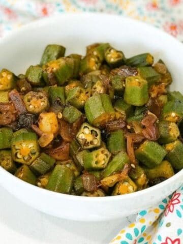 A bowl is with fried okra and onions on the table