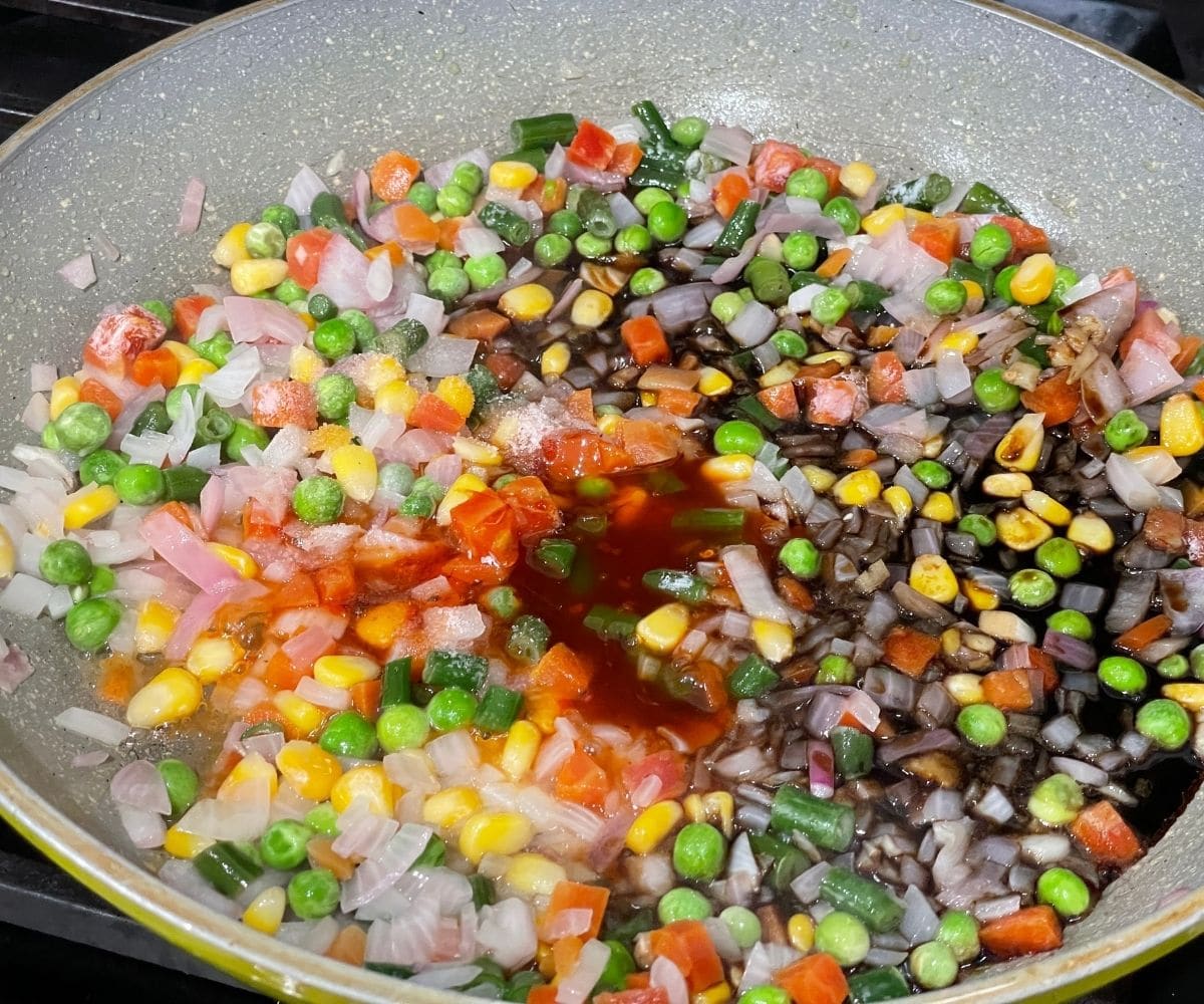 A pan is with veggies and spices for fried rice.
