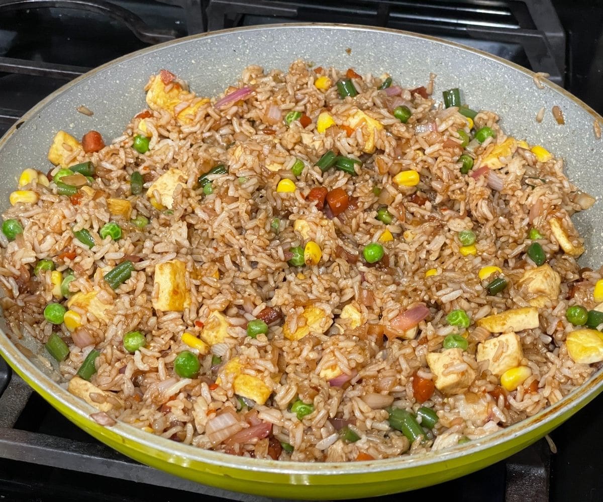 A pan is with vegan fried rice with tofu.