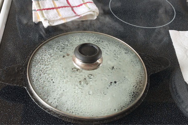 A cast iron pan is with Neer dosa over the heat