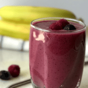 A close up of a glass berry juice, with Banana and Berry