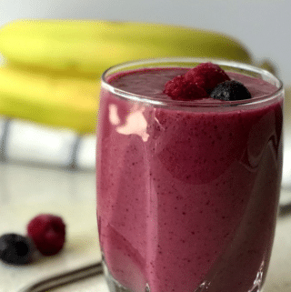 A close up of a glass berry juice, with Banana and Berry