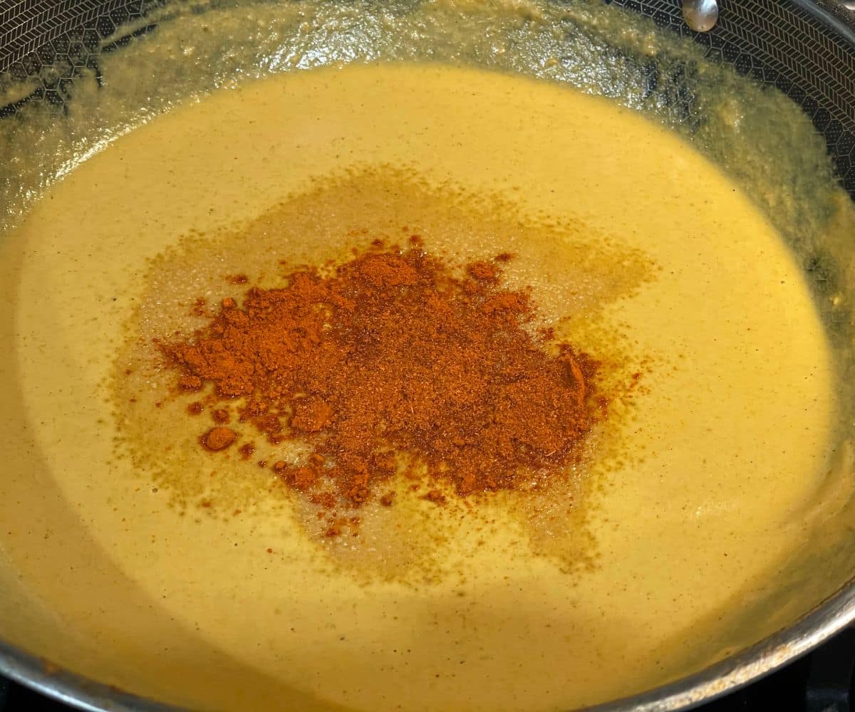 A pot is with vegan tofu paneer butter masala gravy.