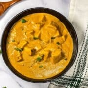 A bowl is filled with vegan tofu butter masala curry.