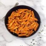 A plate is filled with sun dried tomato pasta.