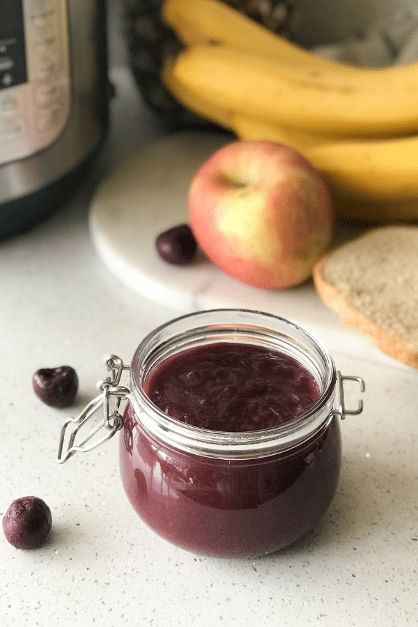 A close up of a bowl of fruit sitting on a table, with Jam