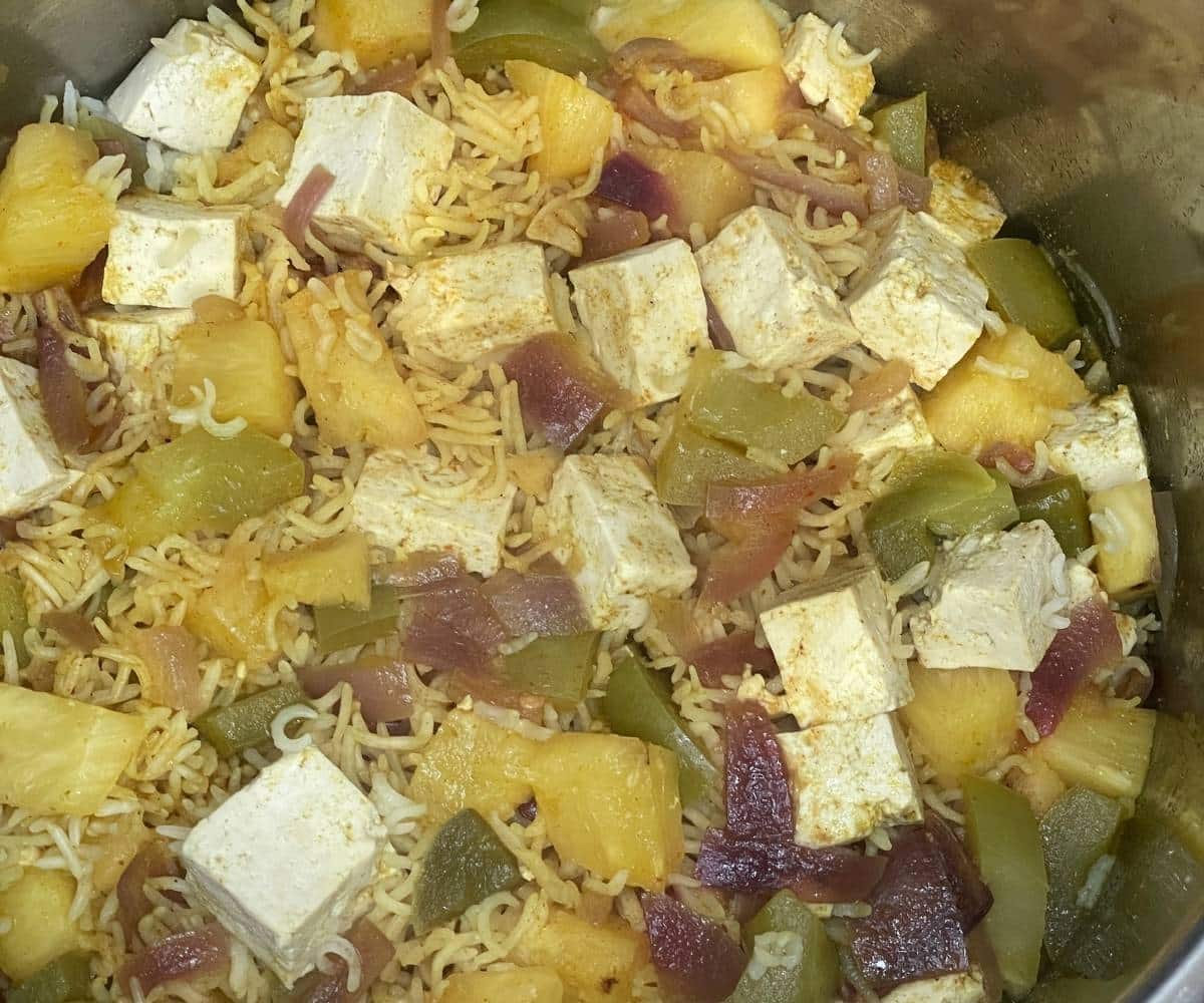 An Instant pot is full of cooked pineapple Thai fried rice.