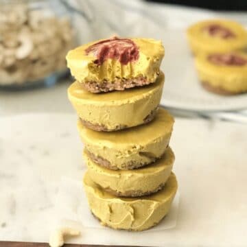 A stack of mini mango no bake cheesecake are on the table.