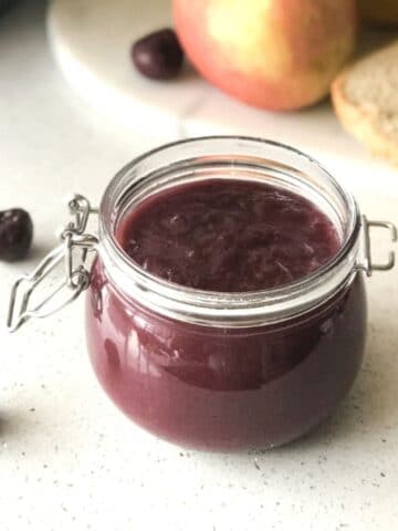 A mason jar is filled with mixed fruit jam.