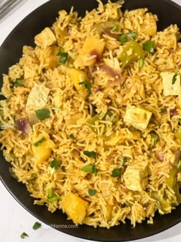 A plate of pineapple fried rice is on the table.