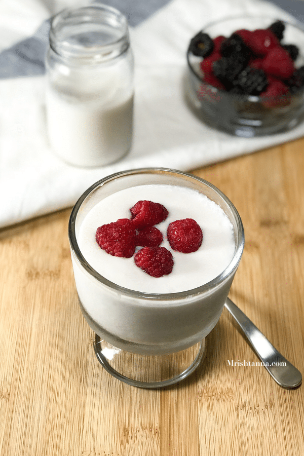 A glass jar is placed on the table with yogurt