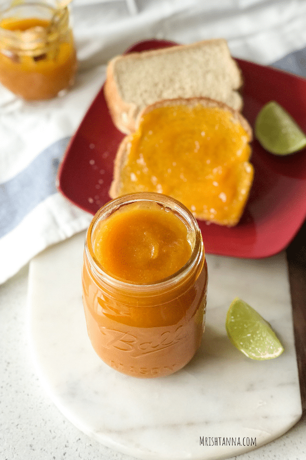 A glass of jam along with toasted bread