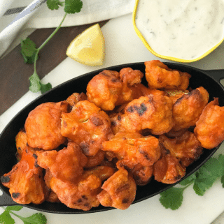 A plate of food, with Buffalo wing and Cauliflower
