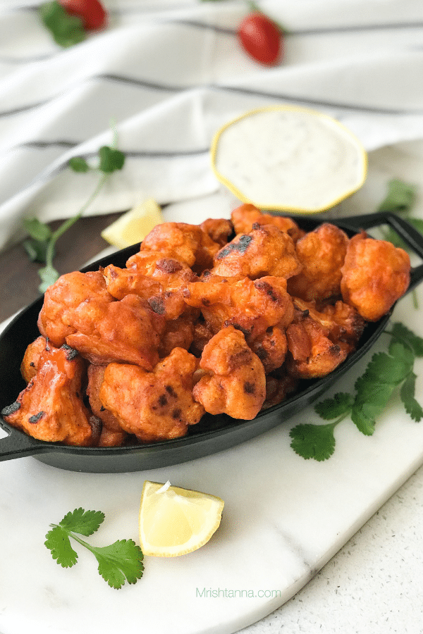 A plate of food on a table, with Cauliflower and Buffalo wing