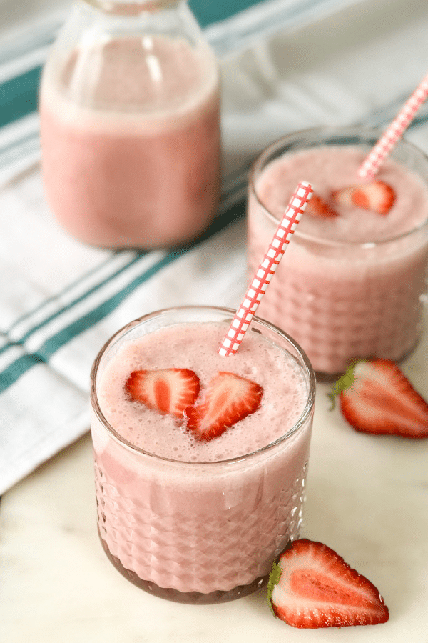 A glass is with strawberry lassi drink.