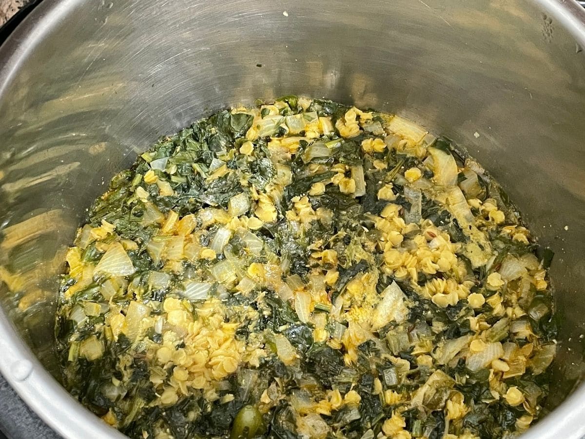 A pot is with palak dal on the counter top.