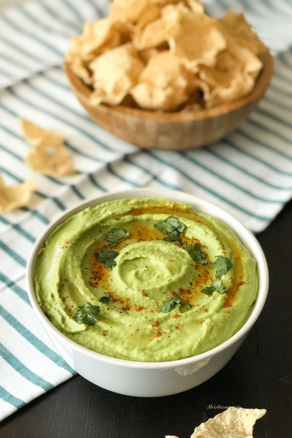 A close up of a plate of food on a table, with Hummus