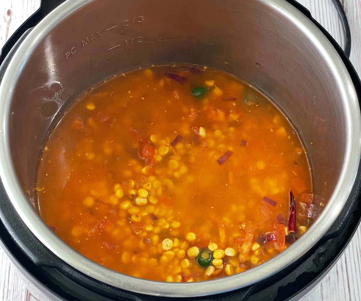 A pot is with chana dal and spices for dal recipe.