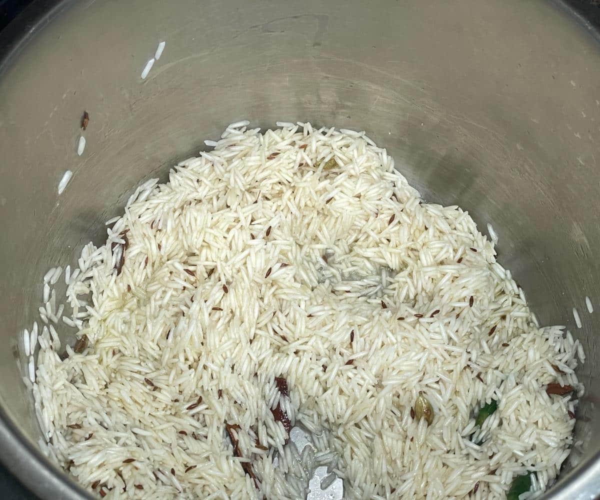An instant pot has basmati rice, cumin seeds for jeera rice.