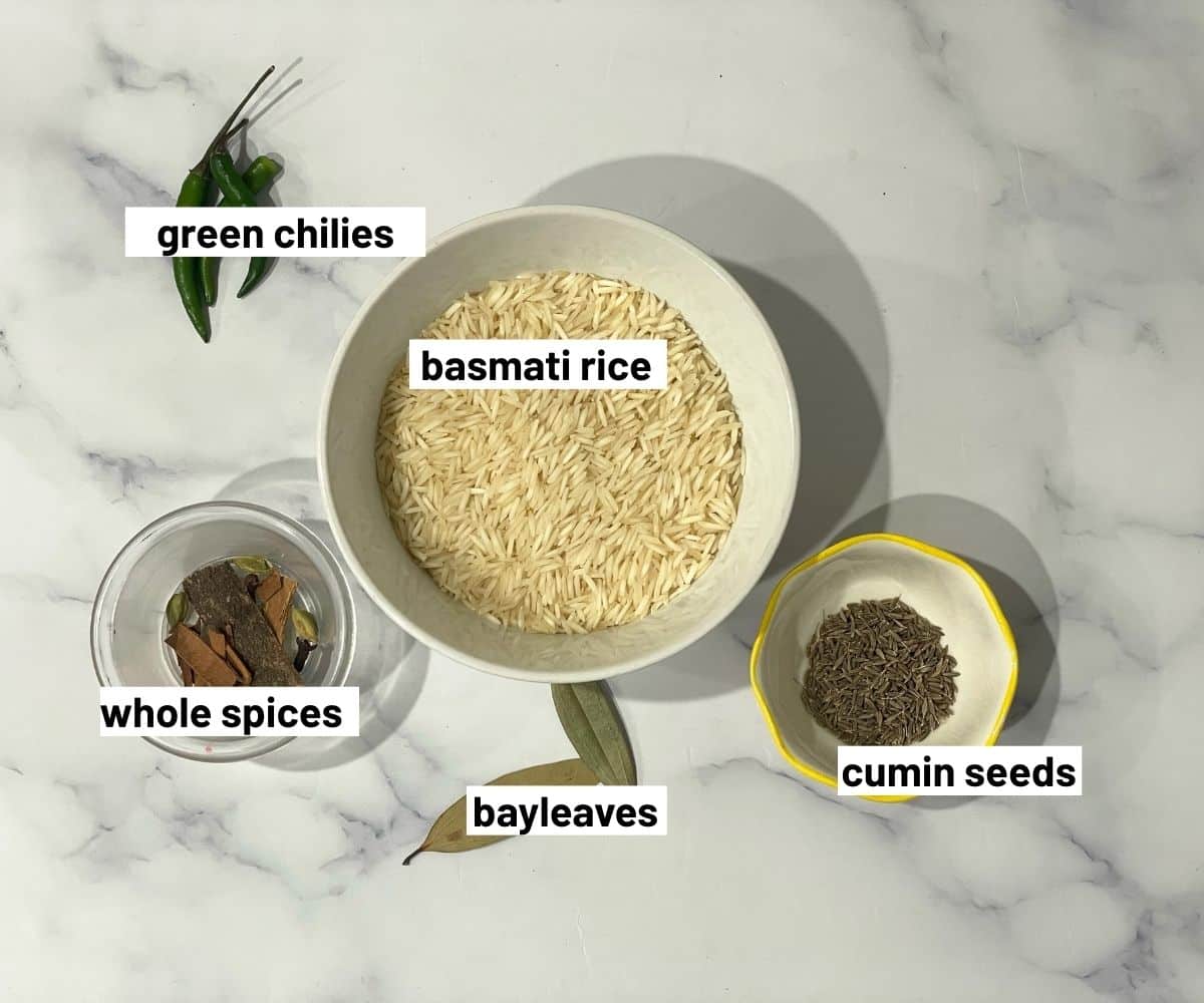 A marble table has jeera rice ingredients.