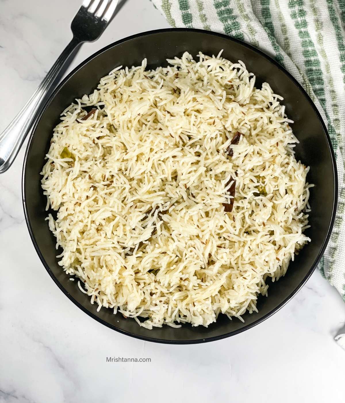 A plate of jeera rice is on the table.