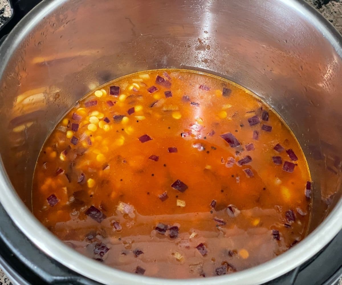 A pot is with water and lentils to make dal fry.