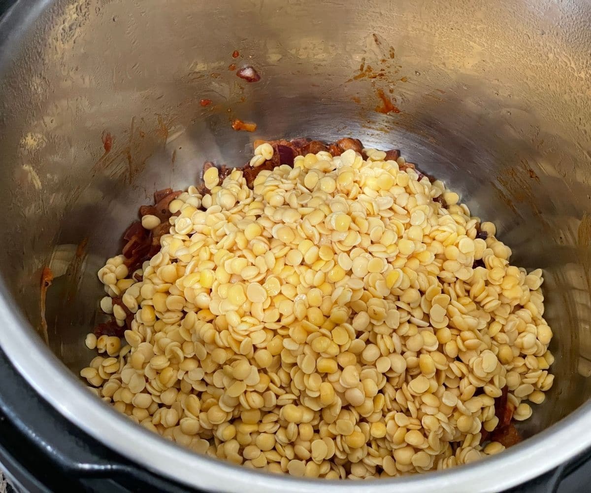 An instant pot is with dal and spices on cooking mode.