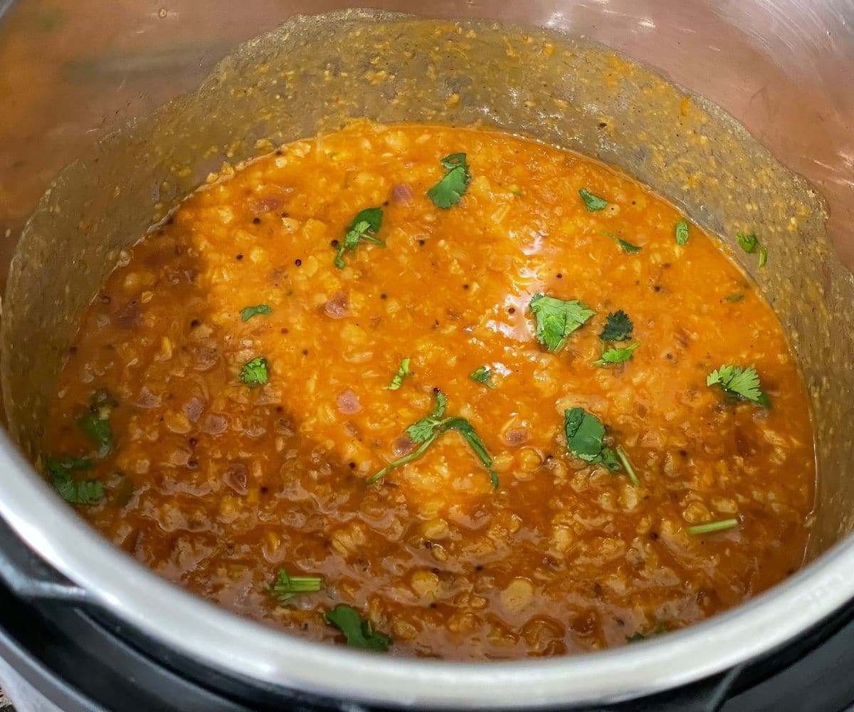 Da tadka is inside the pot and topped with cilantro.