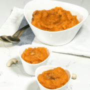 A bowl of halwa on a plate on a table, with Butternut squash