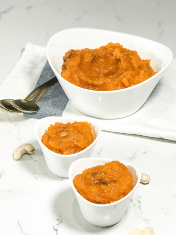 A bowl of halwa on a plate on a table, with Butternut squash