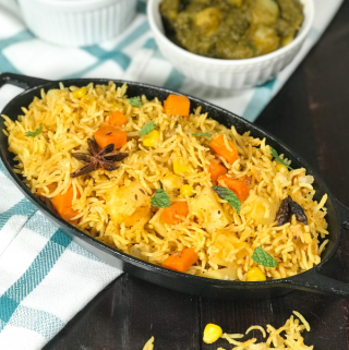 A bowl of food on a plate, with Biryani and Rice