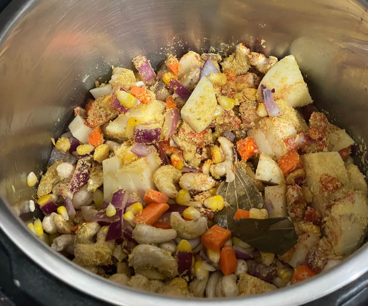 An instant pot is with potatoes and corn chowder mixture.
