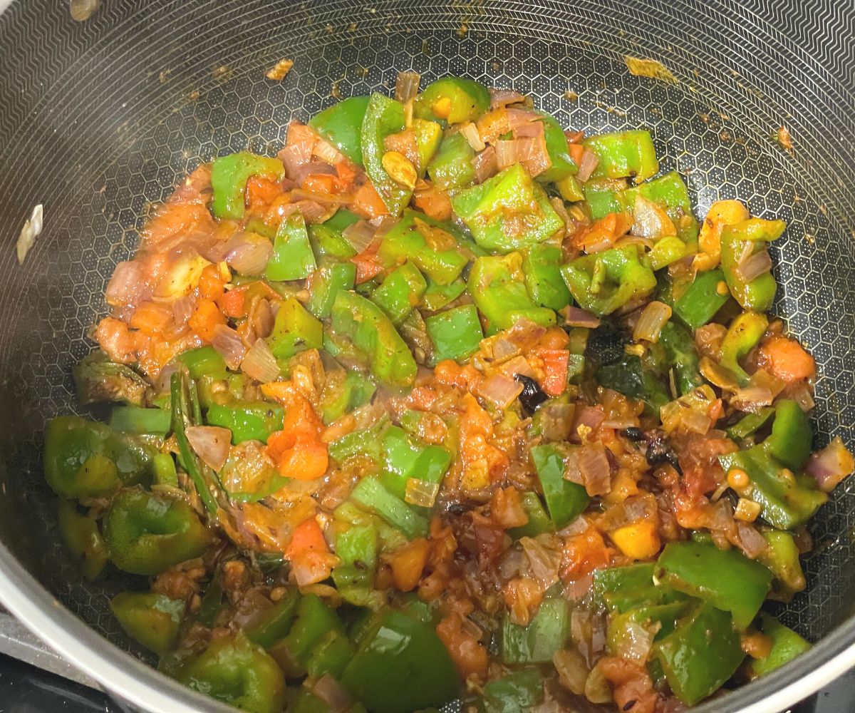 A pan is with capsicum rice masala over the flame.