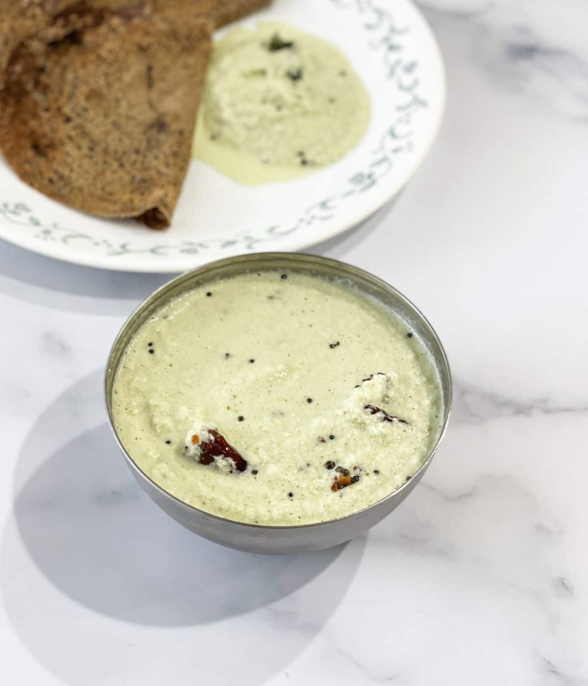 A steel bowl is with nariyal chutney.