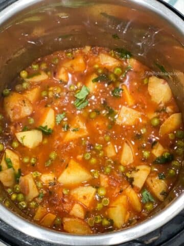An Instant pot is full of aloo matar curry.