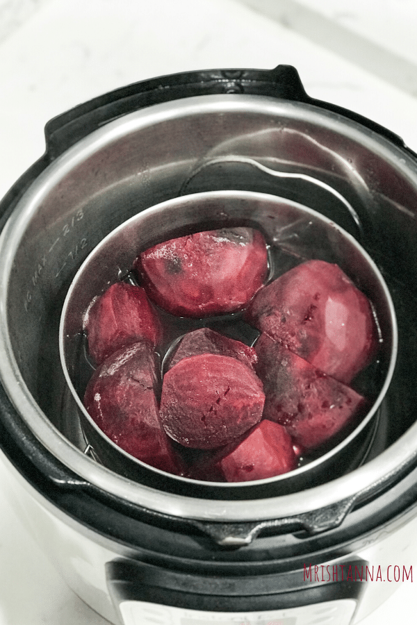 A bowl of food sitting on top of a stove, with Beetroot and Poriyal