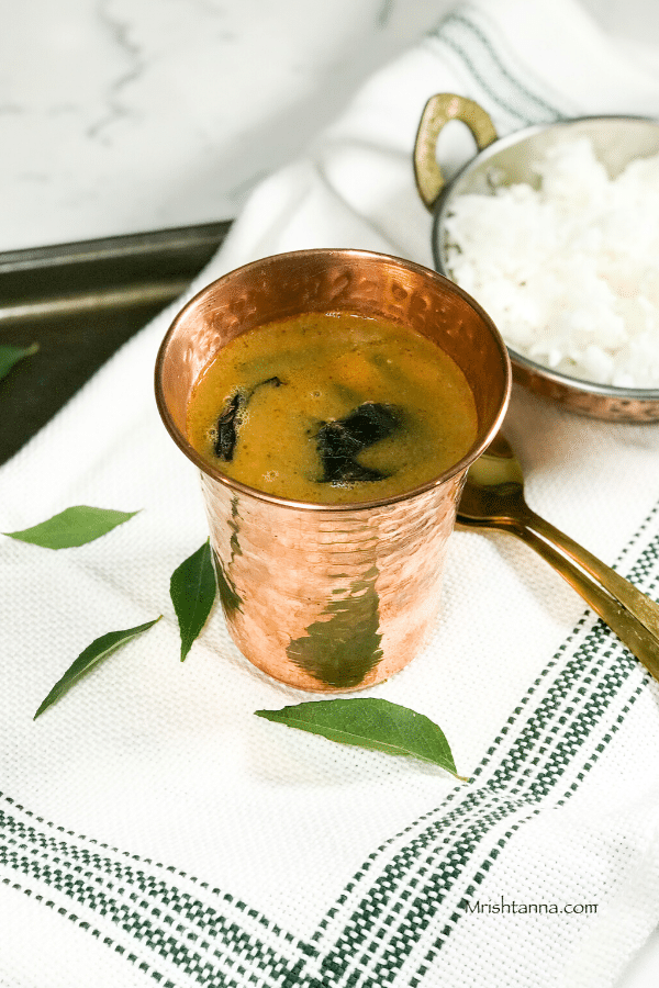 A bowl of food sitting on a table, with Rasam