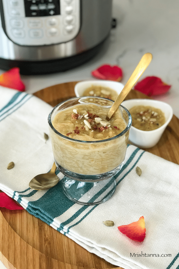 a glass bowl filled with vermicelli kheer and a spoon placed on top