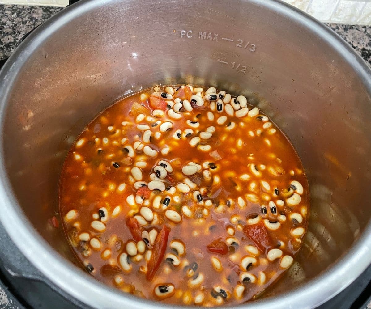 An instant pot is filled with black eyed peas and water 