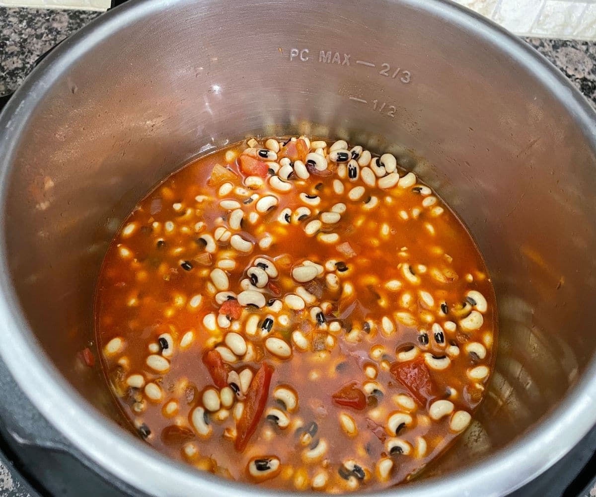 An instant pot is filled with black eyed peas and water