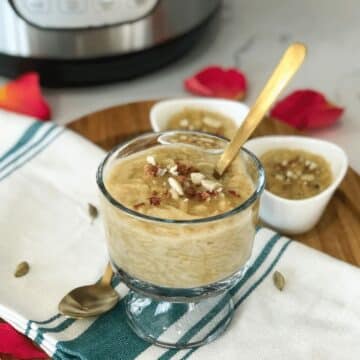 A glass bowl is with semiya kheer and topped with nuts.