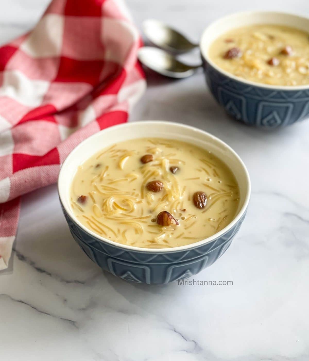 Two bowls are filled with semiya payasam on the table.